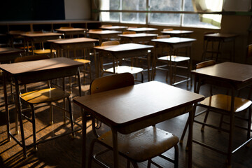 Empty Japanese Classroom with Wooden Desks, Bathed in Warm Sunlight and Dramatic Shadows