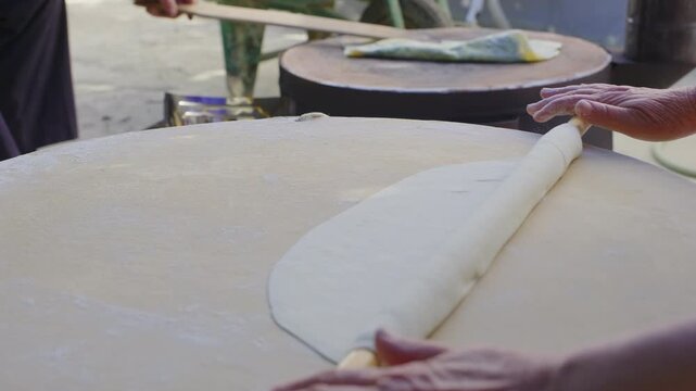 Turkish woman rolling out dough for traditional g&ouml;zleme bread