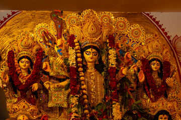 Fototapeta premium A beautifully crafted handmade colorful goddess durga idol decorated for Navratri, featuring vibrant traditional attire, intricate jewellery, and divine expressions at colorful pandal.