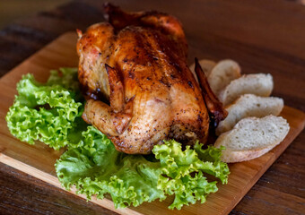 Whole roasted chicken served on a wooden board with fresh lettuce and sliced bread. Warm natural lighting enhances texture, ideal for restaurant menus, recipes, rustic food themes, and festive cooking
