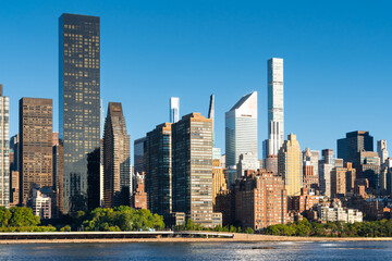 Midtown East Manhattan skyline seen across the East River, with modern skyscrapers and high-rise buildings in morning light. New York City, USA