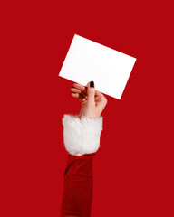 Womans hand in Santa sleeve holding blank card on red background. Christmas mockup
