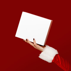 Santa-style hand holding blank white gift box on red background. Perfect for packaging mockups