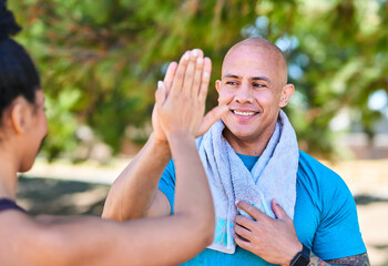 Smiling Man In Blue Shirt High-Fives Friend Outdoors After Workout In Park