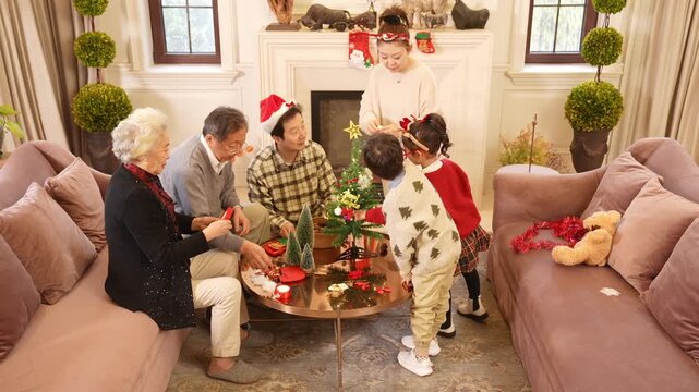 Family hanging Christmas ornaments and string lights