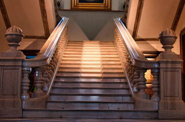 Eleganckie granitowe schody w historycznym wnętrzu z poręczami i ciepłym oświetleniem. © Pol Badger