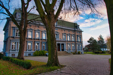 Elegancki zabytkowy pałac z okazałym wejściem, drzewami i brukowaną aleją w otoczeniu parku. Pałac Pogrzebień – neorenesansowy pałac z XIX wieku. © Pol Badger