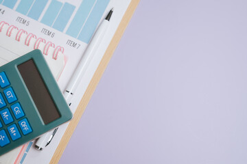 Business concept. Calculator pen notebook financial report workspace office tools business planning accounting analysis organization blue calculator white pen spiral notebook document chart.