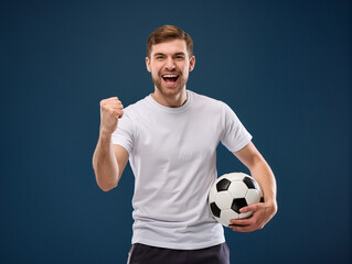 Happy man celebrating victory holding football