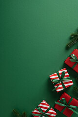 Vibrant vertical holiday scene featuring red and white striped gift boxes tied with green ribbons...