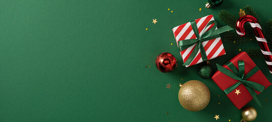 Fototapeta premium Festive banner with wrapped gifts, ribbon, red and gold baubles, and candy cane on a green background. Ideal for Christmas and New Year campaigns, greetings, holiday decor