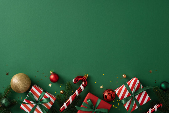A festive holiday display with striped gifts, candy cane, gold ball, pine sprig and confetti evokes Christmas and New Year celebration on a green background - Powered by Adobe