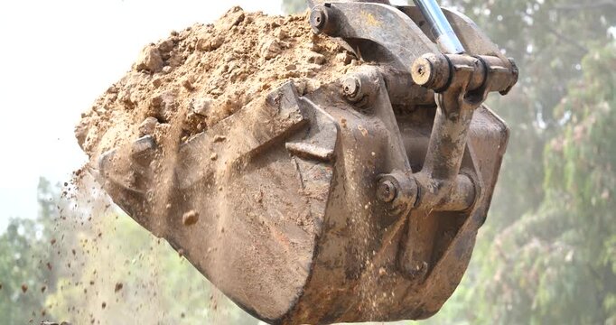 Backhoe excavator digging soil at construction site, backhoe digging soil for trucks