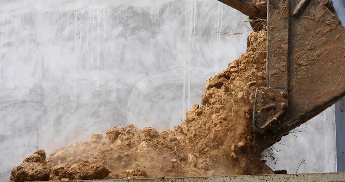 Backhoe excavator digging soil at construction site, backhoe digging soil for trucks