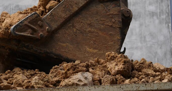 Backhoe excavator digging soil at construction site, backhoe digging soil for trucks