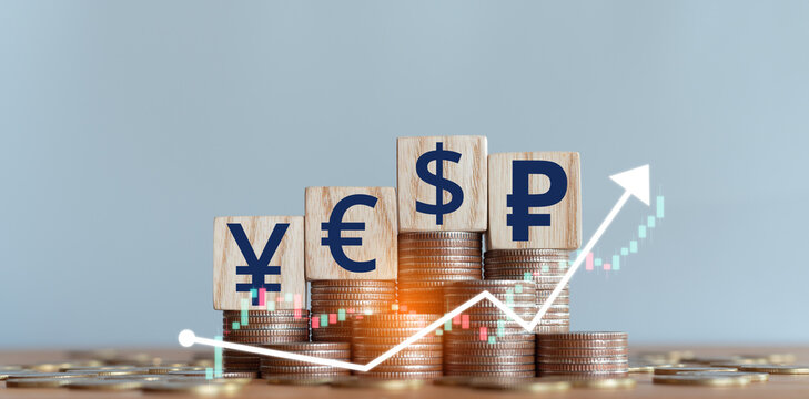 Stacked coins with wooden blocks with world currency symbols representing financial growth, exchange rates, investment, foreign exchange trading and international economy concept. - Powered by Adobe