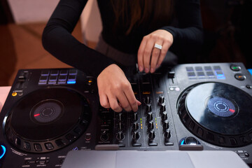 DJ setup overview, Energetic club DJ performing with digital controller in action, Content creator mixing music live using digital turntables under vibrant stage lights