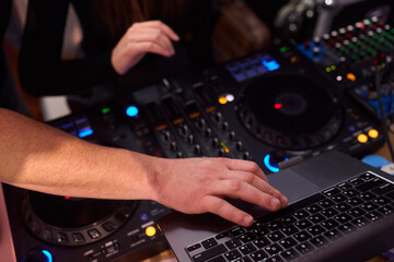 DJ setup overview, Energetic club DJ performing with digital controller in action, Content creator mixing music live using digital turntables under vibrant stage lights