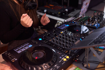 DJ setup overview, Energetic club DJ performing with digital controller in action, Content creator mixing music live using digital turntables under vibrant stage lights