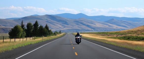 Fototapeta premium The motorcycle rider cruises down a beautiful open road through different states.