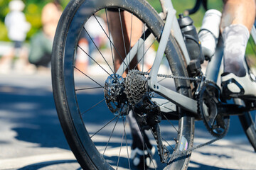 Close-up of a bicycle's rear wheel and drivetrain in motion, showcasing intricate gears and components against a blurred background.