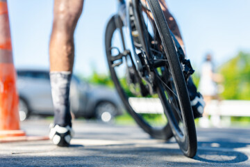 A cyclist's perspective, capturing the bike tire on the pavement with blurred background elements, suggesting motion and speed.