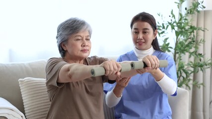Caregiver nurse assisting elderly senior patient in standing exercise during home physiotherapy session, providing medical care and physical support to improve strength, rehabilitation progress