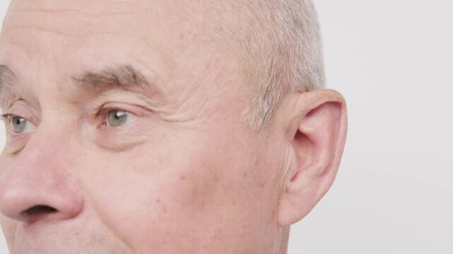 bald man hearing or listening deeply, ear with pained expression, discomfort loud noise, age-related hearing loss, Emotional portrait, discomfort loud noise, Environmental noise, reaction loud sounds