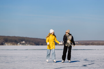 Young women ice skating on frozen lake in winter