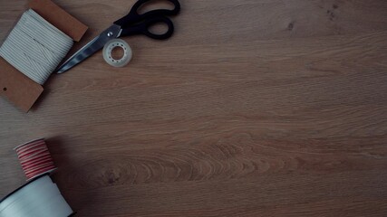 Hands work with basic tools and materials to craft a unique project. Scissors, tape, and paper are used creatively. This process showcases an engaging artistic activity