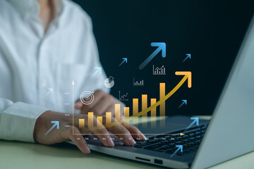 Business growth and financial analytics concept with professional typing on laptop and rising bar chart with upward arrows, representing data analysis, digital strategy, profit increase and success.