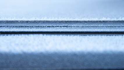 Line of frozen frost ice crystals abstract, cold, winter abstract background with copy space.