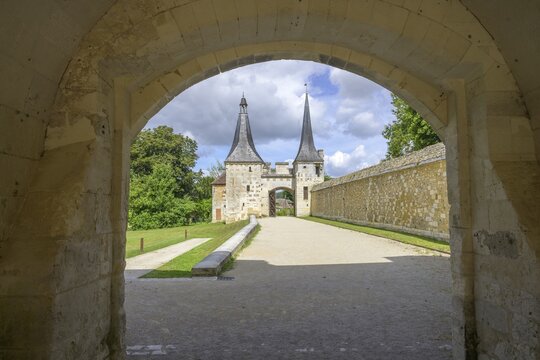 View through archway to the double tower with entrance gate at the Abbey of, Le Bec-Hellouin, Eure, France
