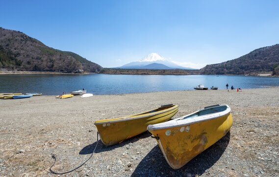 Rowing boats on shore, view across the lake to Mt Fuji volcano, Motosu Lake, Yamanashi Prefecture, Japan