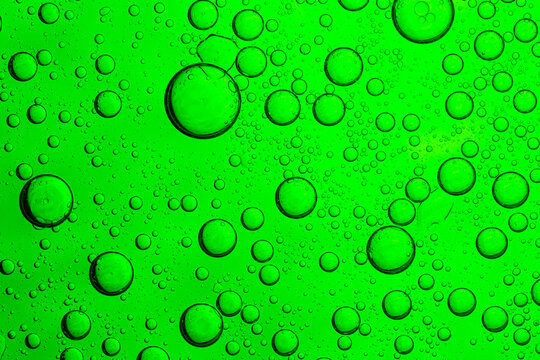 Close-up green macro bubble texture,Macro microscope green bubble texture, Close-up Green bubbles and drops oil background . A detailed image showcasing a vibrant aloe vera liquid for a serum.