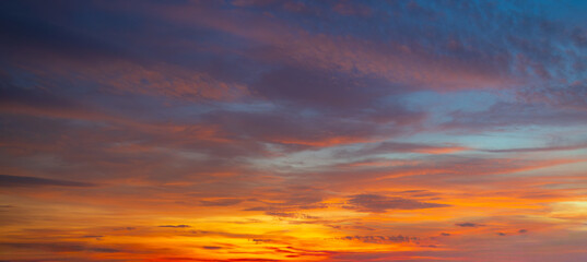 Fototapeta premium Clouds and sky at sunrise and sunset,Clouds and sky at sunrise and sunset,Sunset sky clouds in the evening with Orange gold sunlight in golden hour, Panoramic Horizon sky background 