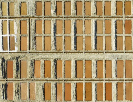 Saline ponds at the salt works next to Almadraba de Monteleva. The reddish colour depends on the level of salinity and is directly caused by the algae Dunaliella salina and brine shrimp. Aerial view. Drone shot. Nature Reserve Cabo de Gata-Nijar, Almer&iacute;a province, Andalusia, Spain