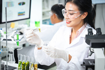 Scientist working in a biology lab examining algae extract for biotechnology and cosmetic research. Test tubes, green samples, and lab equipment highlight natural formulation and scientific innovation