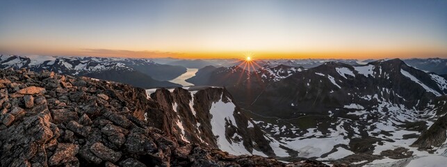 Panorama, view of mountains and fjord Faleidfjorden, sun star at sunset, summit of Skåla, Loen, Norway