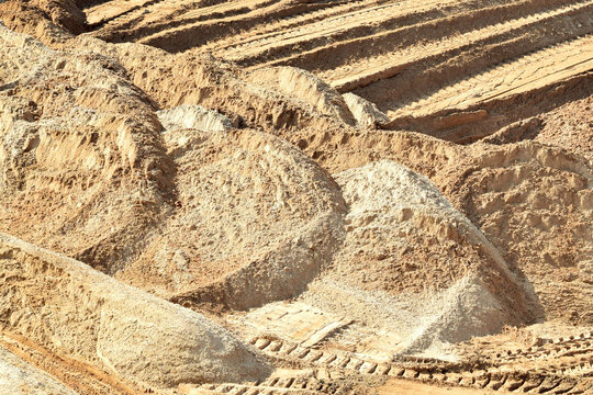 Industrial background. Large piles of sand at a construction site.