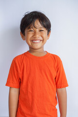Happy Asian child smiling broadly , showing natural joyful expression. portrait with casual look, isolated on white background. Childhood and playful lifestyle concept.