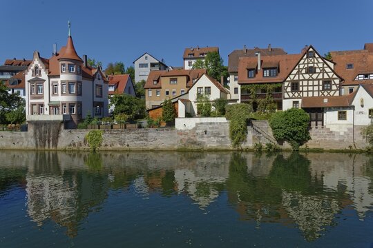 Colourful half-timbered houses are reflected in the calm waters of the River Pegnitz in the town of Lauf, Lauf an der Pegnitz, Middle Franconia, Bavaria, Germany