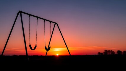 Silhouette of an empty swing set against a dramatic sunset sky vibrant orange and purple hues paint the horizon peaceful outdoor scene at dusk