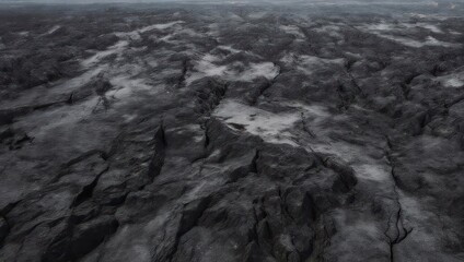 Aerial view of a rugged, textured, and desolate landscape in monochrome.