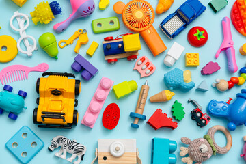Lots of different children's toys on a blue background with space for text, top view, flat lay