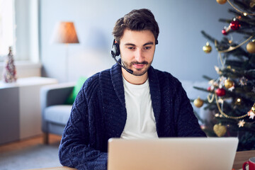 Man with headset working from home during Christmas