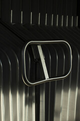 Stainless steel handle on accordion door corrugated panels create repeating vertical lines while...