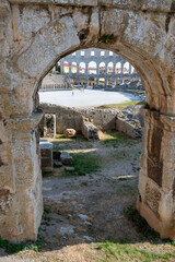 View through a stone arch of the amphitheater in Pula, Croatia