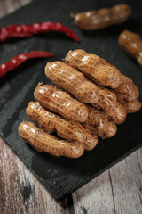 Boiled Peanuts in Shells with Chili Peppers on Slate Board - Traditional Salted Snack Food
