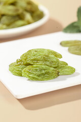 Emerald Green Dried Raisins from Xinjiang on White Plate - Premium Natural Snack Food Photography